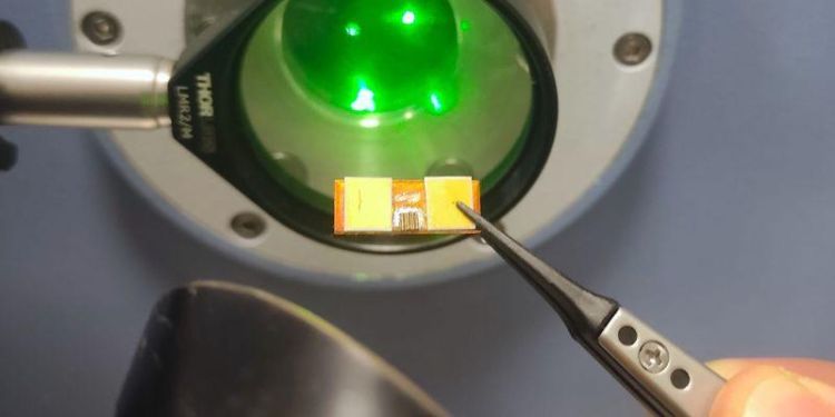 The mode locking terahertz device held between a pair of tweezers.
