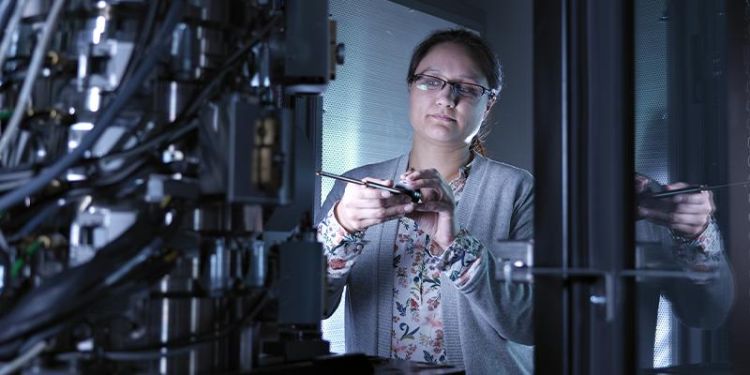 Dr Zabeada Aslam working with an electron microscope in a dimly lit laboratory