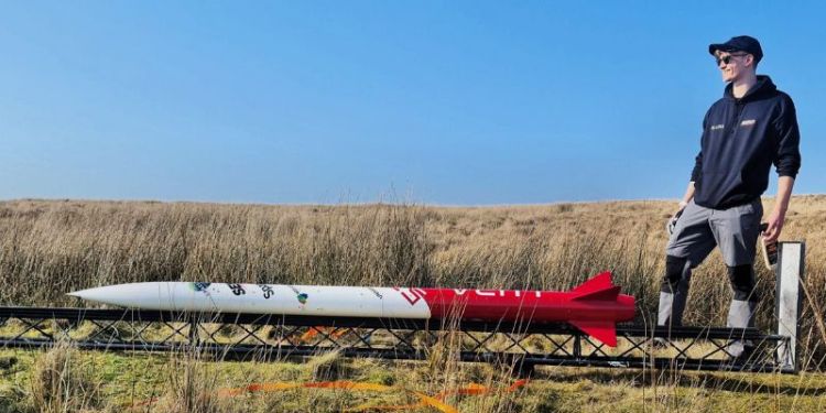 Theo Youds stood on a moor with the Gryphon 1 rocket laid out in front of him.