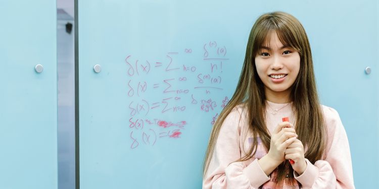 Student standing in front of a whiteboard