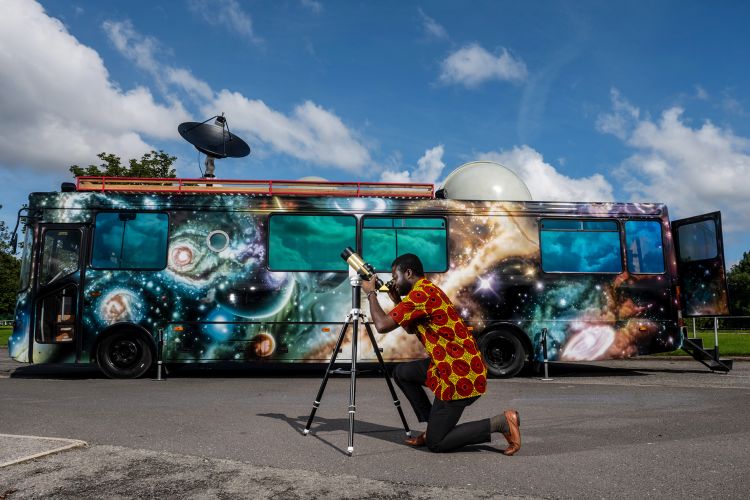 Kingsley Ahenkora-Duodu looking through a telescope outside of the Moon Palace