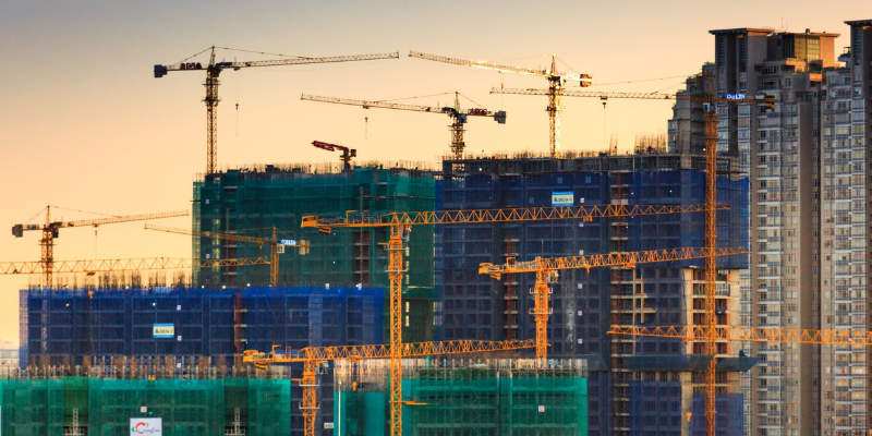 A photograph of a construction site of multiple tower buildings in a city centre.