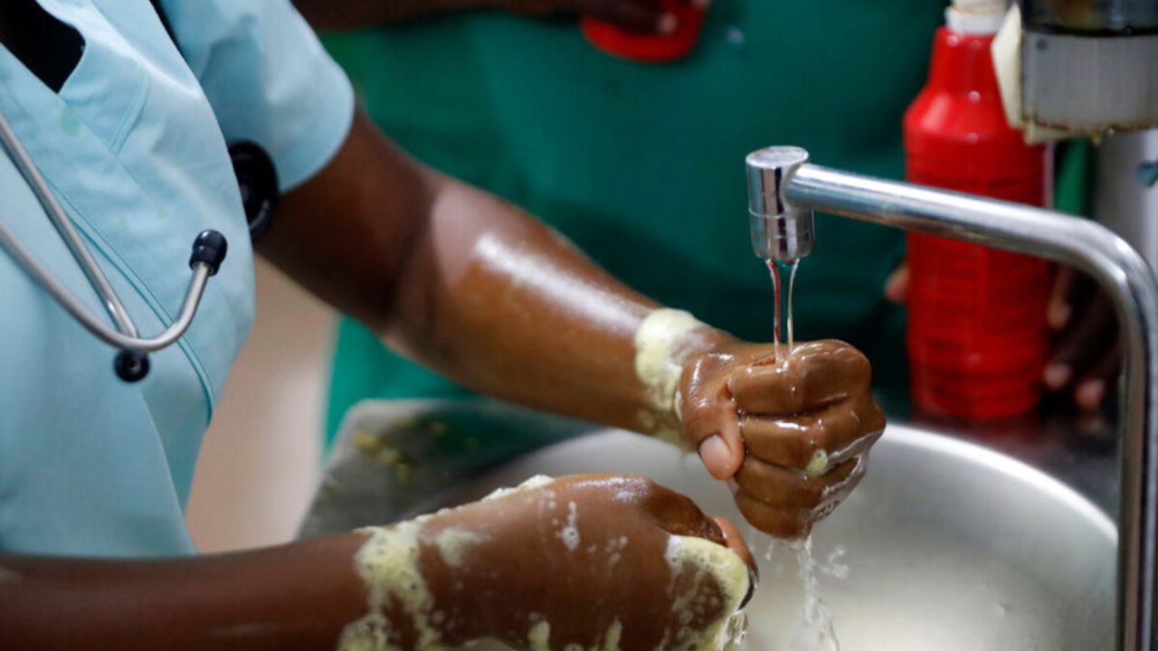 close up of someone washing their hands under a running tap