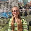 Student Amélie Davies in front of sustainable mural
