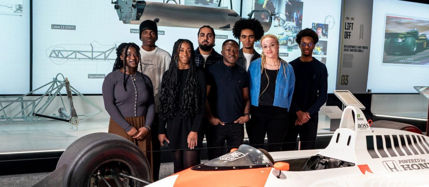2024 MSc Motorsport Scholarships cohort standing in front of a McLaren F1 car