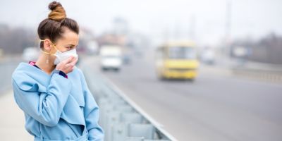 A woman covering her face near passing traffic