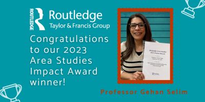 Professor Gehan Selim holding an award presented by Routledge