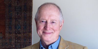 A headshot of John Plane, smiling at the camera