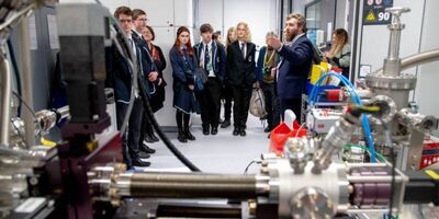 A person pointing at technical equipment in front of several school children