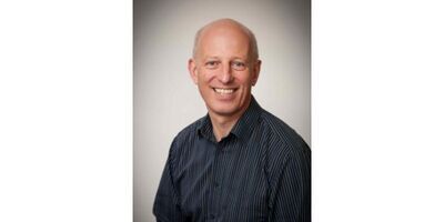Headshot of Tony Cohn wearing a dark shirt