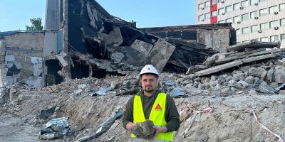 Professor Oleksii Hunyak, from Lviv Polytechnic National University, holding rubble in a bombed building in his country.