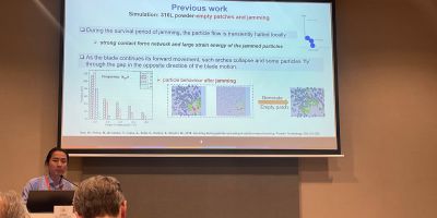 Dr Wei Pin Goh delivers his presentation at the 9th World Congress on Particle Technology. Dr Goh stood in front of a projector.