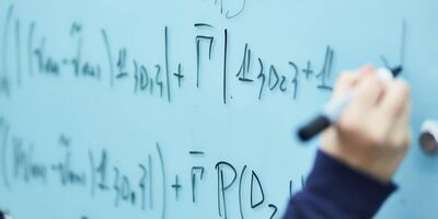 Hand writing equations on a whiteboard
