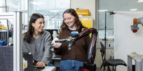 Two students working with a piece of equipment in the Storm Lab at the University of Leeds.