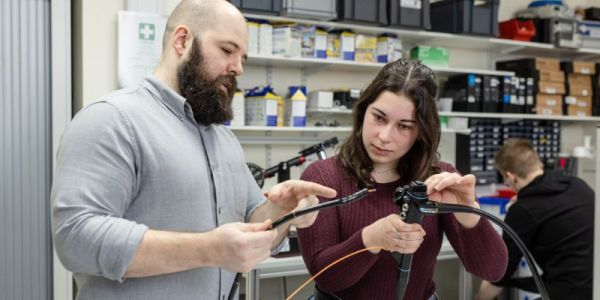 Two students working with a piece of equipment in the Storm Lab at the University of Leeds.