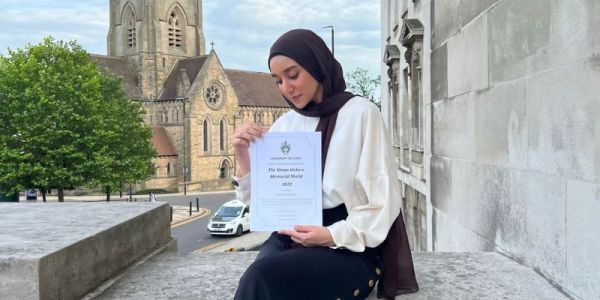 Farida sat on Parkinson steps with her Simon Vickers award.
