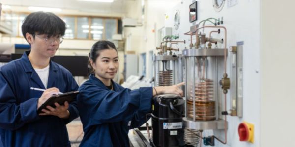 Two students working on a refrigeration bench at in the Thermofluids lab at the University of Leeds.