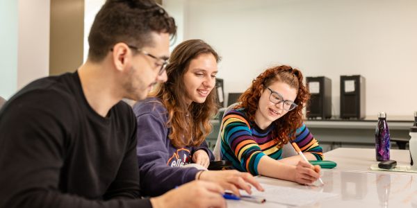 A group of physics students studying at a desk