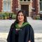 Female student graduating in front of the great hall