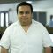 Picture of a man wearing a white shirt, background blurry.