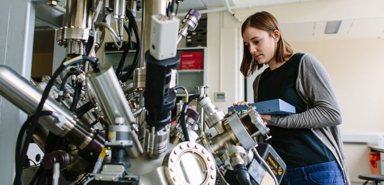Physics postgraduate researcher with equipment