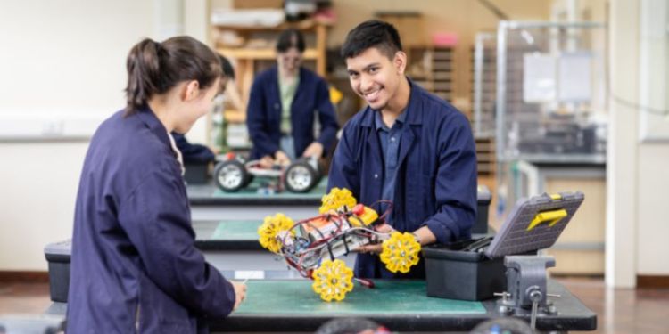 Two students in the Mechanical Engineering workshop, working on a rover.