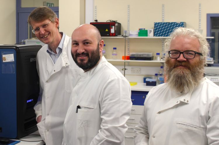 Professor Bruce Turnbull, Dr Darren Machin, and Professor Michael Webb wearing lab coats and standing in a lab.