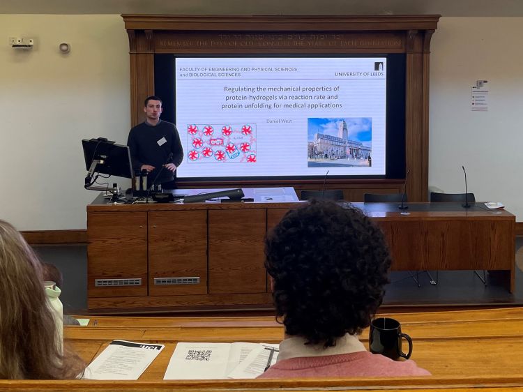 Male student presenting research in a lecture theatre