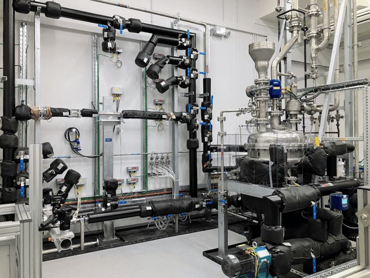 The complex machinery that makes up the water loop, featuring an array of pipes affixed to a wall.